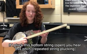 Image of a student playing a homemade banjo