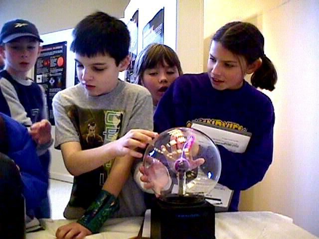 Kids with hands on a plasma ball