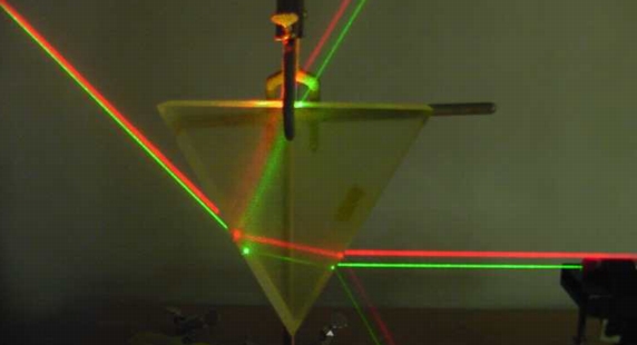 A red and a green laser refracting through a prism